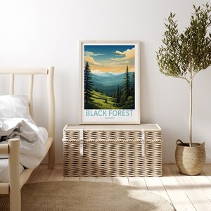 May include: A framed poster with a vintage travel illustration of a forest landscape with mountains in the background. The poster has the text "BLACK FOREST GERMANY" at the bottom.