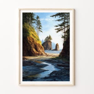 May include: Framed art print of Ruby Beach, Washington. The landscape painting depicts a coastal scene with a sandy beach, ocean, and rocky cliffs. The sky is blue with a few clouds, and the artwork is in a wooden frame.