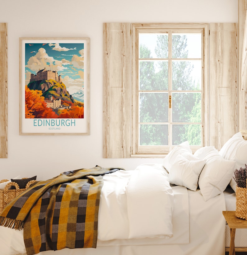 May include: A framed poster with a vintage travel illustration of Edinburgh Castle in Scotland. The poster has a blue and white border and the text "EDINBURGH SCOTLAND" at the bottom. The poster is hanging on a white wall above a bed with white bedding and a yellow and black plaid throw blanket.