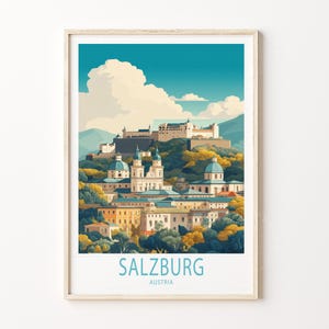 May include: A framed art print showing a stylized illustration of Salzburg, Austria. The artwork depicts a cityscape with buildings, domes, and a castle atop a hill, set against a blue sky with clouds. The text "SALZBURG AUSTRIA" is at the bottom.