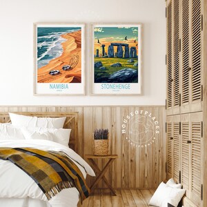 K&ouml;nnte beinhalten: Zwei gerahmte Reiseposter, eines zeigt eine W&uuml;stenlandschaft mit einem Jeep, der an einem Sandstrand in Namibia, Afrika, f&auml;hrt, und das andere zeigt Stonehenge in England.