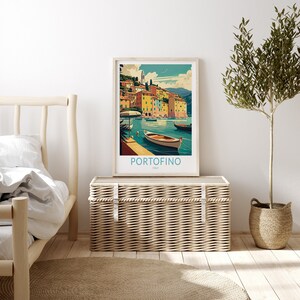May include: A vintage travel poster with a colorful illustration of the Italian town of Portofino. The poster features a harbor with boats and buildings in the background. The text on the poster reads "Portofino, Italy".