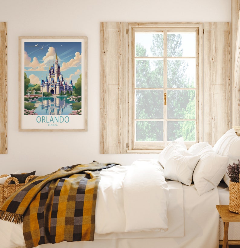 May include: A framed print of a colourful illustration of Cinderella's Castle at Walt Disney World in Orlando, Florida. The print is hanging on a wall above a white bed with a yellow and black plaid blanket.
