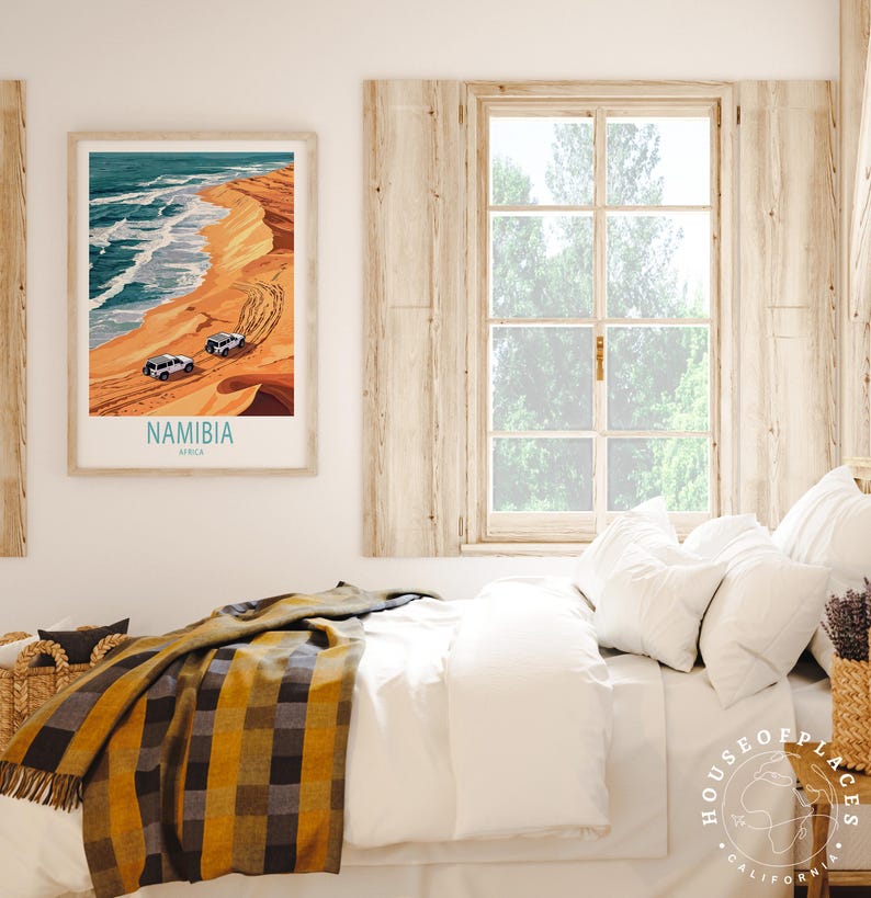 K&ouml;nnte beinhalten: Ein Vintage-Reiseposter mit einem blauen und wei&szlig;en Bild eines Strandes in Namibia, Afrika. Das Poster ist gerahmt und h&auml;ngt an einer wei&szlig;en Wand &uuml;ber einem Bett mit einer wei&szlig;en Bettdecke und einer gelb-schwarzen karierten Wolldecke.