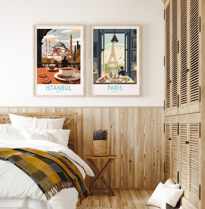 May include: Two framed travel posters with illustrations of Istanbul, Turkey and Paris, France. The Istanbul poster shows a view of the Hagia Sophia mosque with a couple enjoying a cup of coffee. The Paris poster shows a view of the Eiffel Tower with a person enjoying a meal at a cafe.