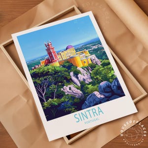 May include: A travel poster of Sintra, Portugal, depicting Pena Palace in vibrant colours atop a green hill. The poster is in a wooden frame, set on brown paper. The text "Sintra Portugal" is at the bottom.
