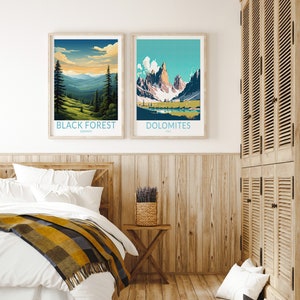 May include: Two framed landscape posters with mountain scenes. The poster on the left shows a forest scene with the text "BLACK FOREST, GERMANY". The poster on the right shows a mountain range with the text "DOLOMITES, ITALY".