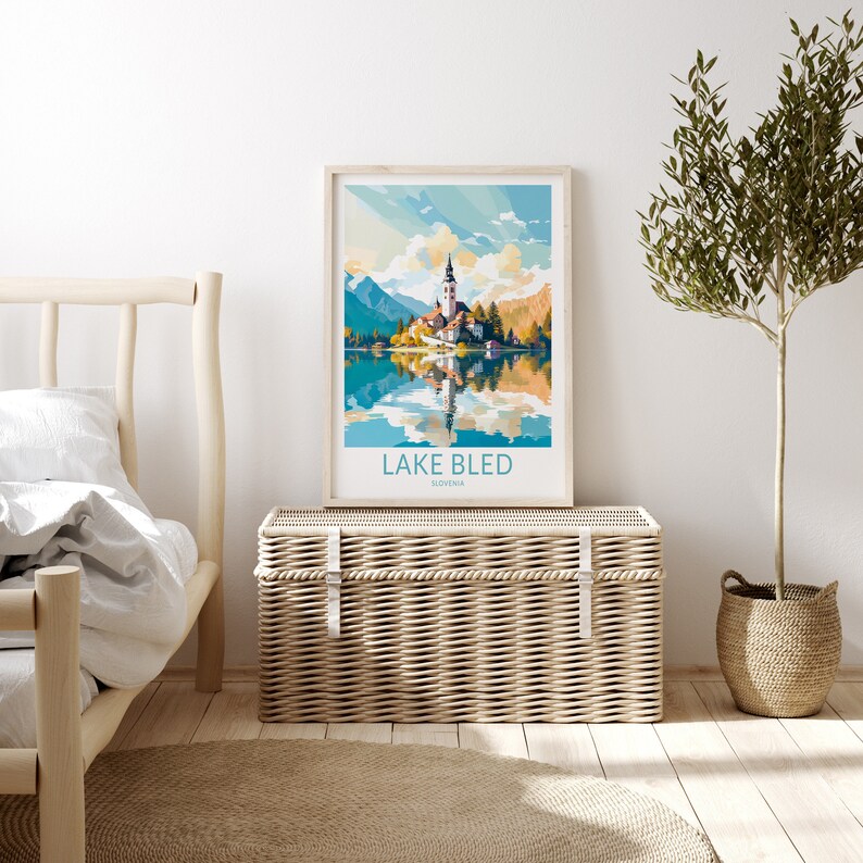 Op de afbeelding: Een vintage poster met een kleurrijke illustratie van het meer van Bled in Sloveni&euml;. De poster toont een kerk op een eiland in het meer, omringd door bergen en bomen. De tekst "LAKE BLED" en "SLOVENIA" is in blauw gedrukt aan de onderkant van de poster.