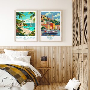 May include: Two framed travel posters, one depicting a beach scene with palm trees and the text "PLAYA DEL CARMEN, MEXICO" and the other depicting a colorful cityscape with the text "RIJEKA, CROATIA". The posters are hanging on a light wood wall above a white bed with a yellow and black blanket.