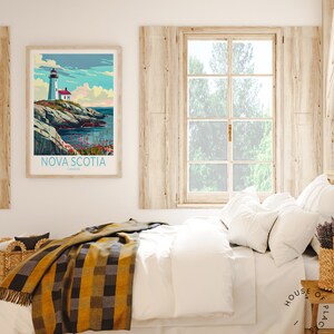 K&ouml;nnte beinhalten: Ein gerahmtes Poster mit einer Leuchtturmszene aus Nova Scotia, Kanada, h&auml;ngt &uuml;ber einem Bett mit wei&szlig;er Bettw&auml;sche und einer gelb-schwarz karierten Decke. Der Raum hat eine rustikale, gem&uuml;tliche Atmosph&auml;re mit Holzakzenten und einem Fenster.