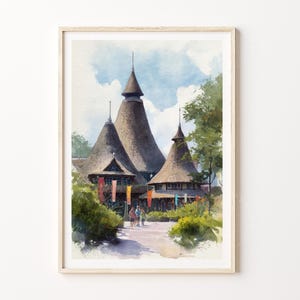 May include: Watercolor print of a building with three tall, conical thatched roofs. The artwork features a pathway, greenery, and colorful flags. The sky is a light blue with fluffy white clouds, and the artwork is framed in a light wood frame.