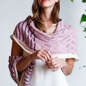 May include: A woman wearing a pink and white striped shawl with a delicate lace pattern. The shawl is draped over her shoulders and she is looking directly at the camera.