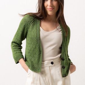 May include: A green knitted cardigan with a button closure. The cardigan has a slightly cropped length and a relaxed fit.