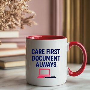 May include: White ceramic mug with a red interior and handle. The mug features the text "CARE FIRST DOCUMENT ALWAYS" in blue, along with a pink laptop and a black pen graphic. The mug is on a marble surface.