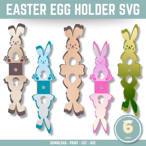 May include: Six different Easter bunny egg holders. Each holder is a different color: brown, beige, blue, pink, green, and white. The bunny holders are designed to hold an egg in the center of the bunny's body.  The text "Available in 6 Themes" is at the bottom of the image.