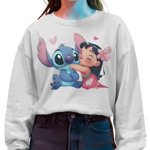 May include: White sweatshirt with a blue and pink cartoon image of Stitch and Lilo from the Disney movie Lilo & Stitch. Stitch is hugging Lilo and they both have hearts around them.