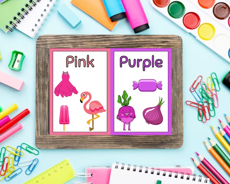 May include: Two flashcards with the words "Pink" and "Purple" written on them. Each card has pictures of objects in the corresponding color. The pink card has a dress, a popsicle, and a flamingo. The purple card has a candy, a radish, and an onion.