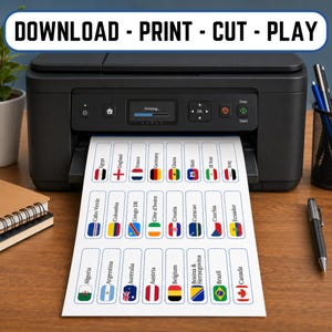 Op de afbeelding: Een zwarte printer print een vel papier met vlaglabels van landen. De labels bevatten vlaggen uit Algerije, Argentini&euml;, Australi&euml;, Oostenrijk, Belgi&euml;, Brazili&euml;, Canada en meer. De tekst bovenaan luidt "DOWNLOAD - PRINT - CUT - PLAY".