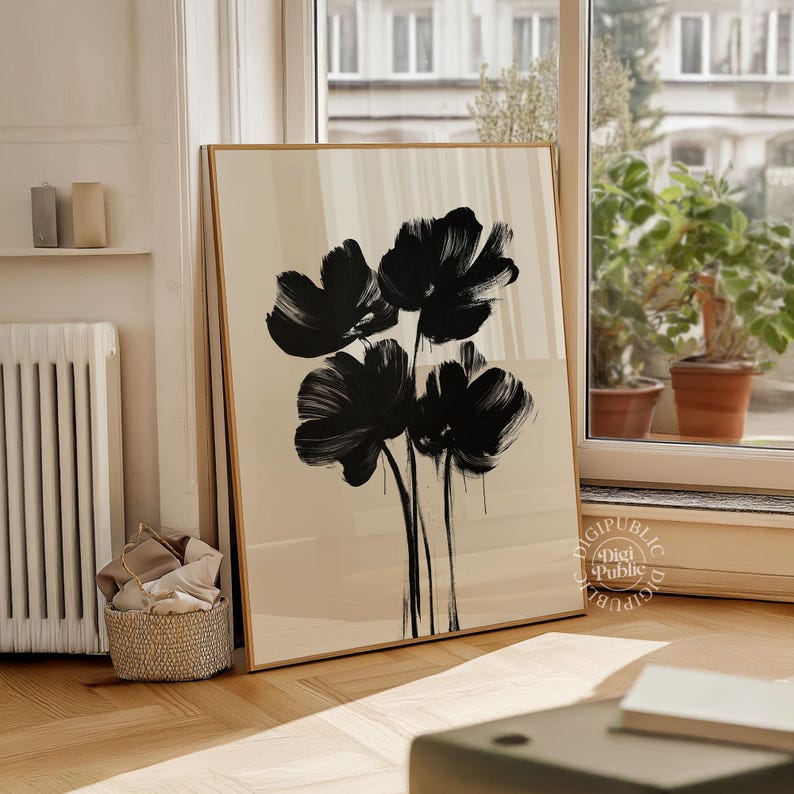 May include: A framed art print featuring a minimalist floral design. The artwork showcases four large, abstract black flowers against a cream-colored background. The print is displayed in a room with natural light and wooden floors.