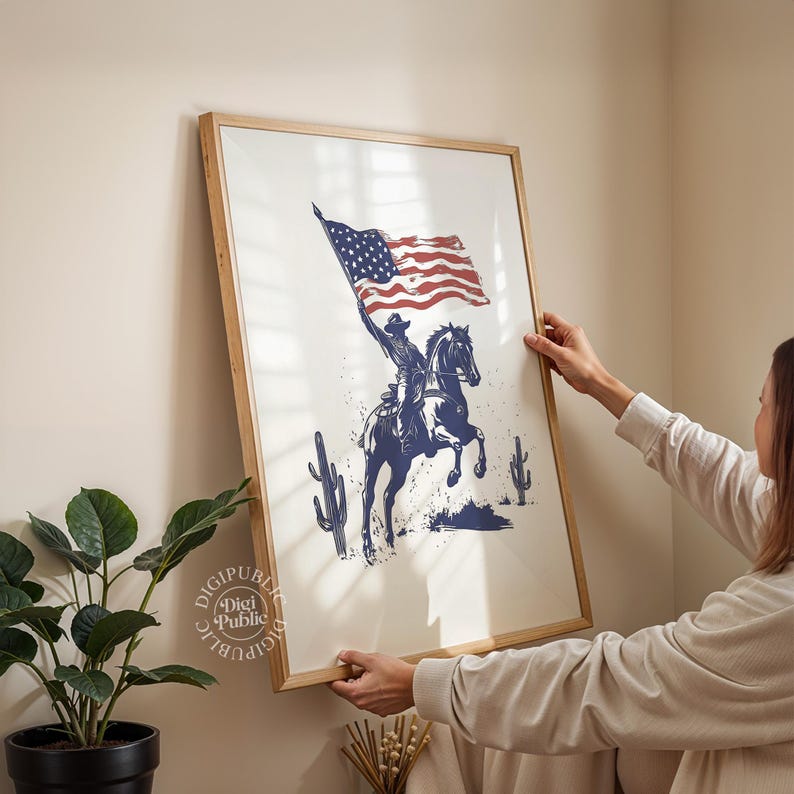 A vintage-style illustration of a cowboy on horseback waving an American flag, flanked by two cacti — perfect for rustic western or patriotic-themed decor.