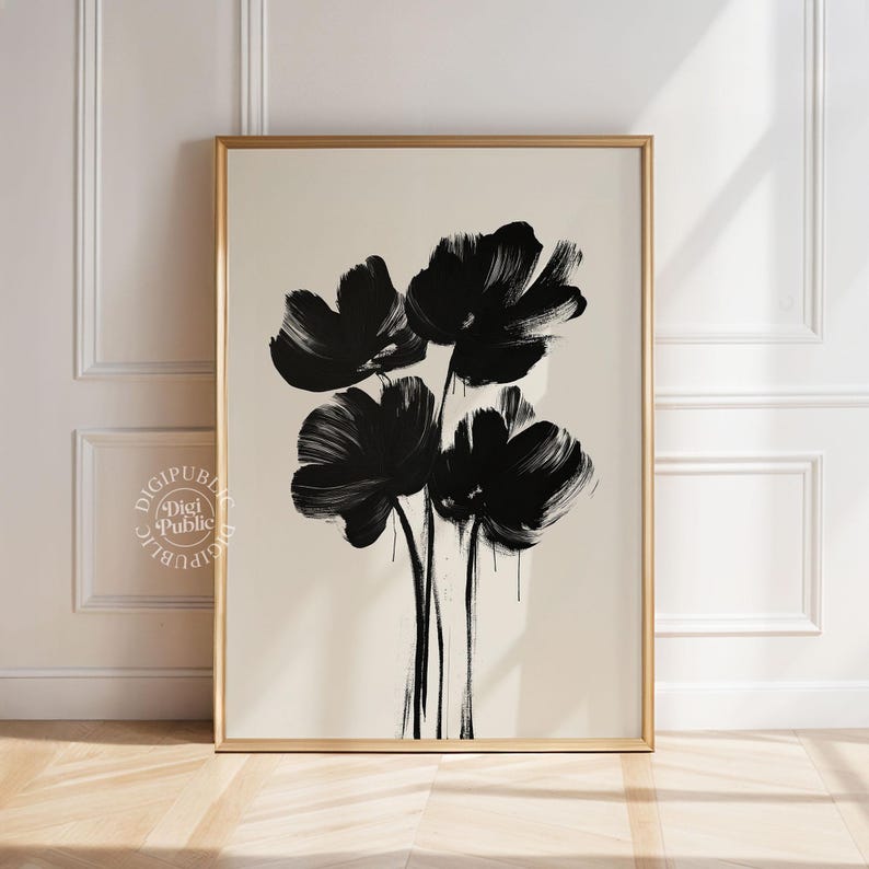May include: A framed art print featuring a minimalist floral design. Bold black brushstrokes depict four stylized flowers against a neutral background. The artwork is encased in a gold-colored frame, adding a touch of elegance.