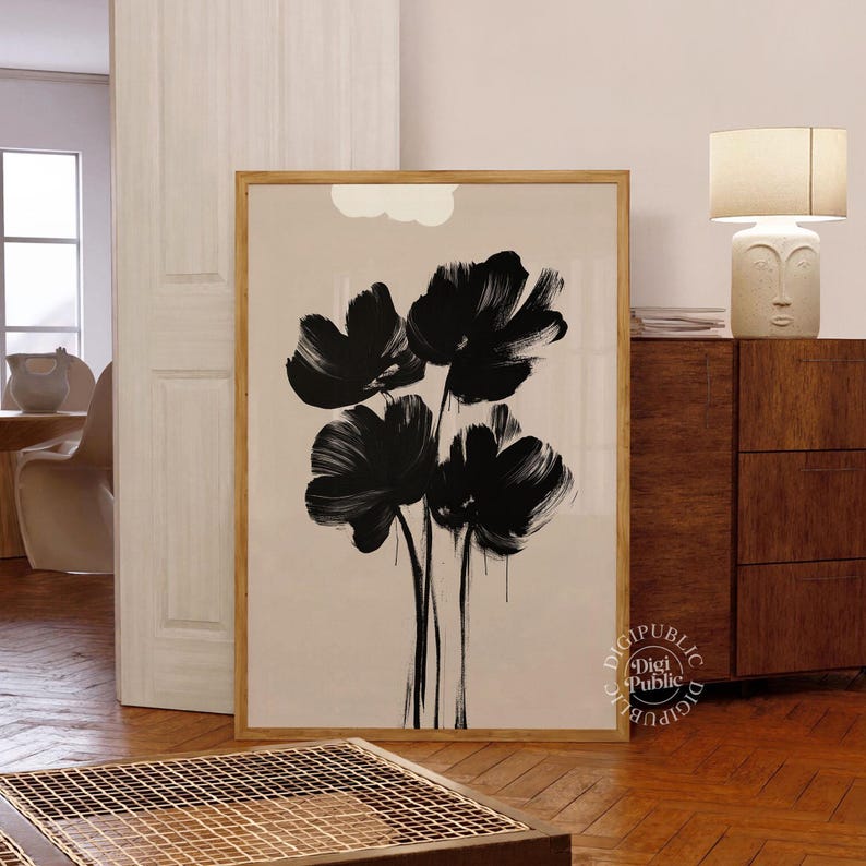 Framed digital artwork of abstract black flowers created with bold brush strokes on a light background, minimalist botanical printable wall art.