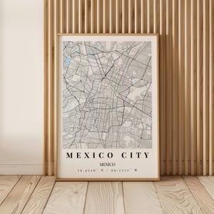 Può includere: Una stampa cartografica incorniciata di Città del Messico che mostra una rete stradale dettagliata in tonalità di grigio e nero con elementi acquatici azzurri. Il testo in basso riporta MEXICO CITY, MEXICO, seguito dalle coordinate 19.4326 N / 99.1332 W.