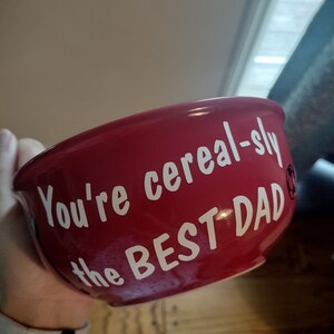 May include: Red ceramic bowl with white text that reads "You're cereal-sly the BEST DAD".