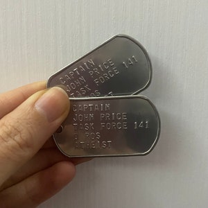 May include: Two silver dog tags with the text "CAPTAIN JOHN PRICE TASK FORCE 141" and "CAPTAIN JOHN PRICE TASK FORCE 141 O POS ATHEIST" engraved on them.