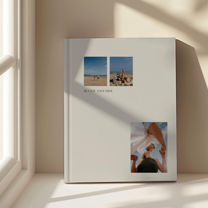 May include: A cream-coloured photo album featuring three small rectangular images. The top two show people on a beach. The bottom image shows a person looking upwards. The words "BETTER TOGETHER" are printed on the album.