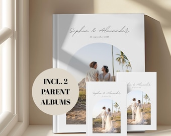 Puede incluir: Un conjunto de álbumes de boda blancos con los nombres "Sophia & Alexander" y la fecha "26 de septiembre de 2025" en escritura elegante. Los álbumes presentan una foto de pareja y el texto "INCL. 2 PARENT ALBUMS".