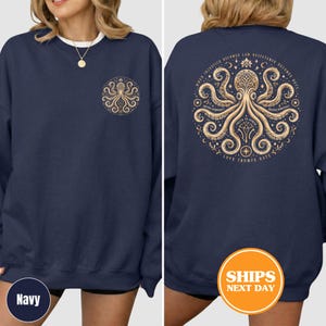 Puede incluir: Sudadera azul marino con un dise&ntilde;o de pulpo dorado en la parte delantera y trasera. El dise&ntilde;o trasero incluye el texto "Cuando la injusticia se convierte en ley, la resistencia se convierte en deber". La sudadera tiene cuello redondo y mangas largas.