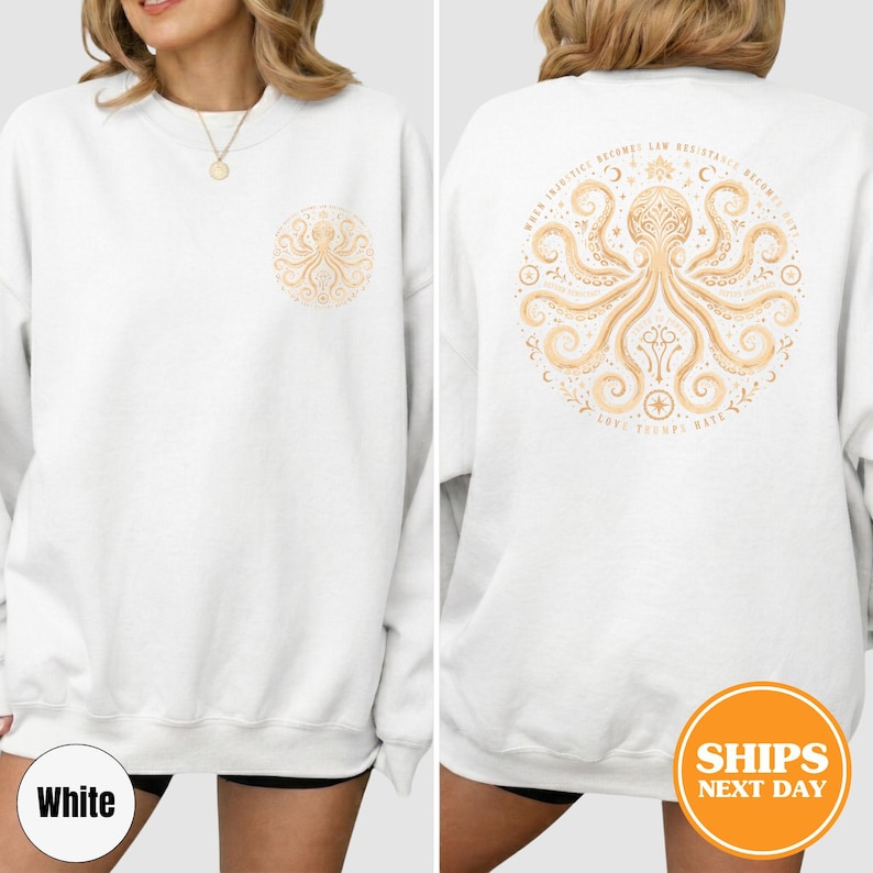 Puede incluir: Sudadera blanca con un dise&ntilde;o detallado de pulpo en un patr&oacute;n circular en la parte delantera y trasera. El dise&ntilde;o de la espalda incluye el texto "WHEN INJUSTICE BECOMES LAW RESISTANCE BECOMES DUTY" y "LOVE TRIUMPHS HATE".