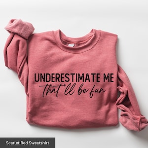 a pink shirt that says, underestimate me that i'll be