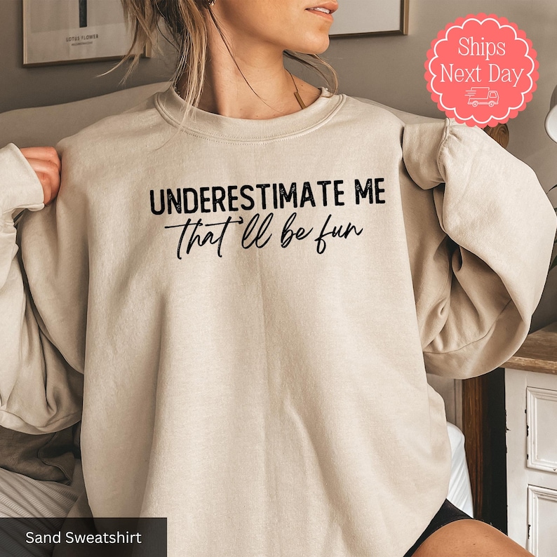 a woman wearing a sweatshirt that says, underestimate me that'll