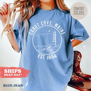 a woman wearing a blue shirt with a lighthouse on it