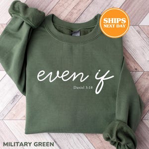 May include: A military green long-sleeve crewneck sweatshirt featuring the white text "even if" in a cursive script font, with the smaller white text "Daniel 3:18" printed directly underneath the main phrase on the front of the garment.