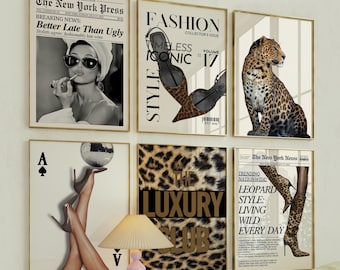 May include: Six framed art prints with gold frames. The prints feature fashion-themed images, including a woman with sunglasses, high heels, a leopard, and text that reads "The Luxury Club". The prints are displayed on a white wall.
