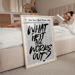 Könnte beinhalten: Ein gerahmter Druck mit dem Text "WHAT IF IT ALL WORKS OUT?" auf einem Zeitungs-Hintergrund. Der Druck hat einen hellen Holzrahmen. Die Zeitung ist vom 27. Juli 2025, von The New York News.