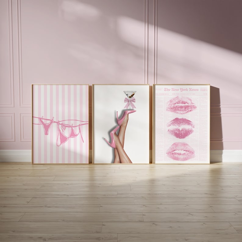 May include: Three framed art prints with a pink theme. One print shows pink lingerie hanging on a clothesline. Another features legs in pink heels holding a martini. The third displays pink lip prints.