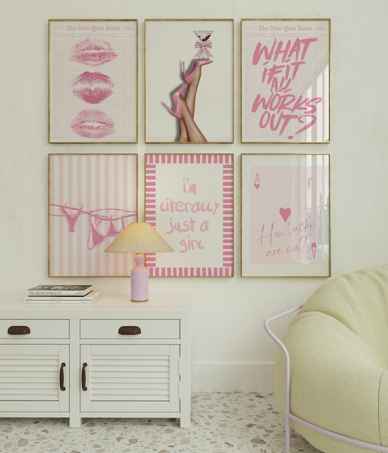 May include: A gallery wall featuring six framed prints in pink and white tones. The art includes pink lips, legs in pink heels with a martini, the text "WHAT IF IT ALL WORKS OUT?", lingerie on a clothesline, the text "i'm literally just a girl", and an ace of hearts card with the text "How lucky are we?" above a lamp and white cabinet.