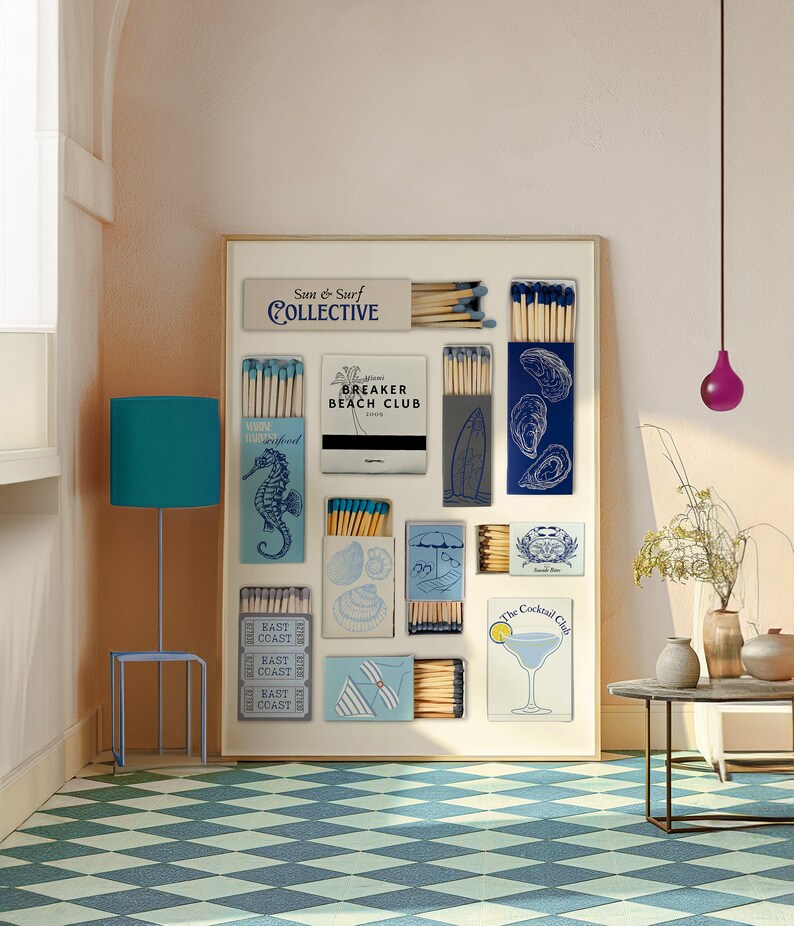 May include: A framed collage of matchboxes with various beach-themed designs, including seashells, a surfboard, an oyster, and a cocktail glass. The matchboxes are arranged in a grid pattern on a white background. The text "Sun & Surf Collective" is at the top of the collage.