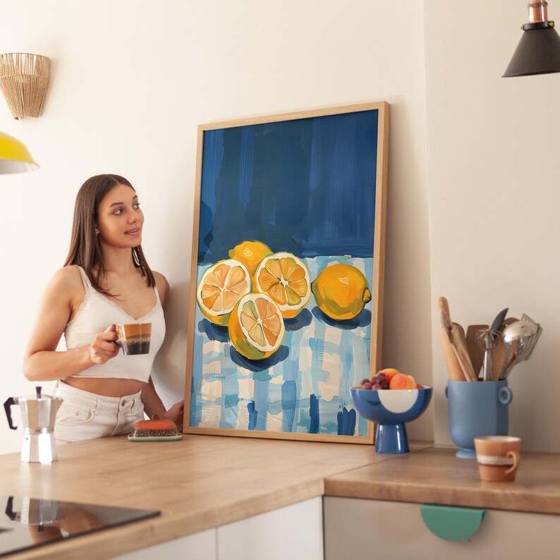 May include: A framed painting of lemons on a blue and white checkered tablecloth. The lemons are yellow and have a glossy finish. The painting is set against a dark blue background.