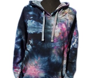 May include: A tie-dye hoodie with a dark blue, pink, and white color scheme. The hoodie has a drawstring hood and a kangaroo pocket.
