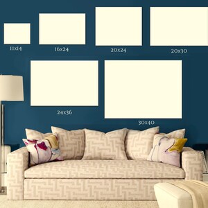 Puede incluir: Una sala de estar con un sof&aacute; beige y una pared azul. Hay cinco marcos blancos de diferentes dimensiones colgados en la pared. Los marcos est&aacute;n etiquetados con sus dimensiones en pulgadas. El sof&aacute; tiene dos almohadas con patrones florales y una tercera almohada con un patr&oacute;n geom&eacute;trico.