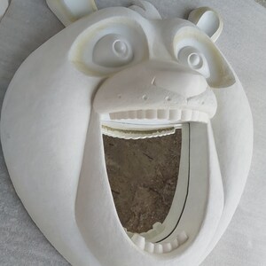 Puede incluir: Un espejo de pared blanco con forma de oso y boca muy abierta. El espejo tiene un dise&ntilde;o tallado detallado, que incluye los ojos, la nariz y las orejas del oso. El marco del espejo es texturizado y el dise&ntilde;o general es caprichoso y decorativo.