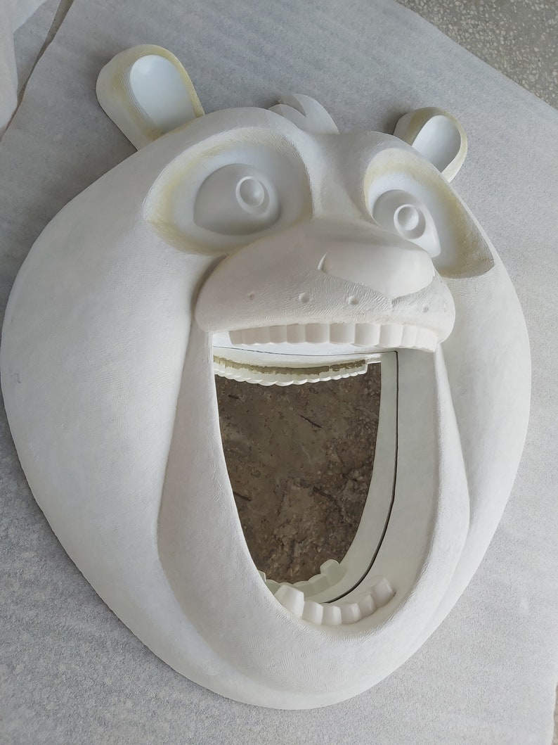 Puede incluir: Un espejo de pared blanco con forma de oso y boca muy abierta. El espejo tiene un dise&ntilde;o tallado detallado, que incluye los ojos, la nariz y las orejas del oso. El marco del espejo es texturizado y el dise&ntilde;o general es caprichoso y decorativo.