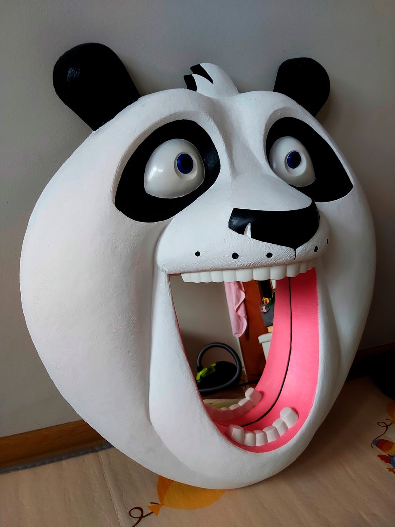 Puede incluir: Una gran escultura de cabeza de panda blanca con orejas y parches negros. La boca del panda est&aacute; abierta, revelando una lengua rosa y dientes blancos. Los ojos son grandes y azules. La escultura est&aacute; dise&ntilde;ada para montarse en la pared.
