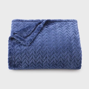 May include: A plush, blue blanket with a chevron pattern. The blanket is folded, with a corner turned down, revealing the soft texture. The color is a deep, rich blue, and the material appears to be a soft, fuzzy fabric.