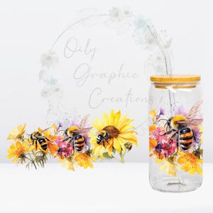 May include: A clear glass tumbler with a bamboo lid and a stainless steel straw. The tumbler is decorated with watercolor illustrations of bees, sunflowers, and wildflowers. The text "Oily Graphic Creations" is visible.